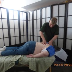 Mr. Kramer performing energy healing treatment on a man who is faced down.
