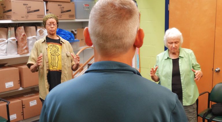 Ken Kramer looking at two women during a group healing session.